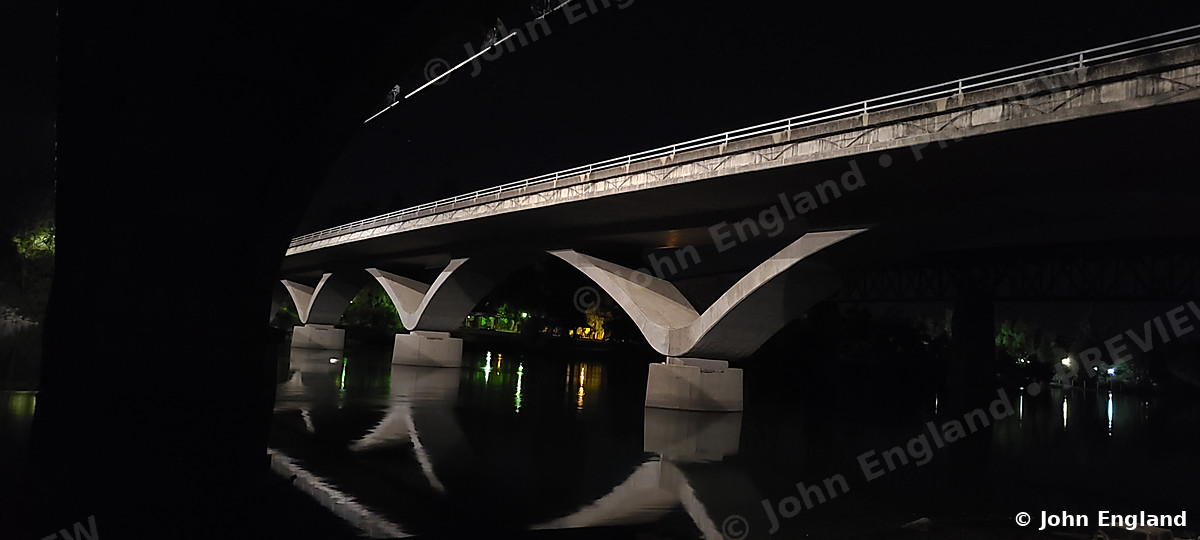 Arched Bridge at Night – Arched bridge at night with reflections.