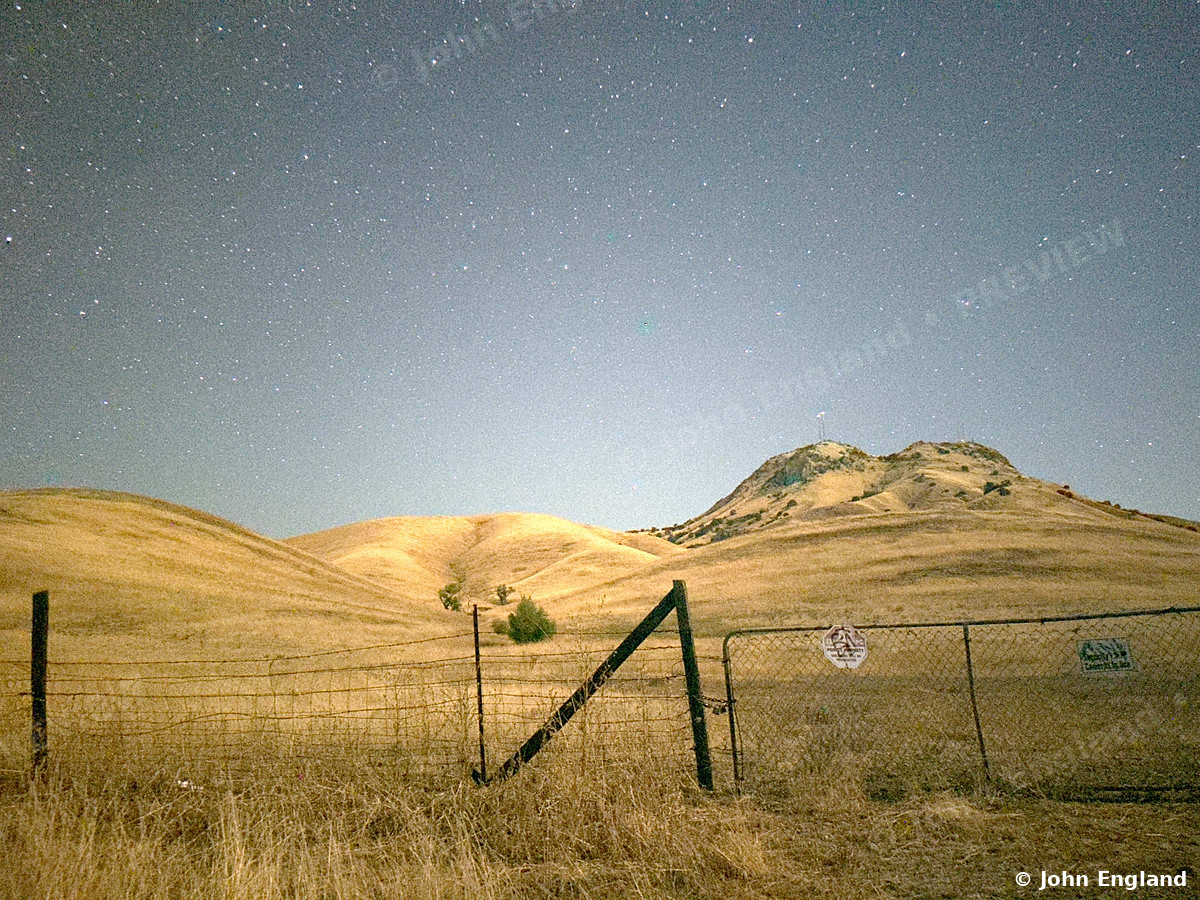 Stars over the Fence Line – Stars over golden foothills behind a fence line, Northern California.