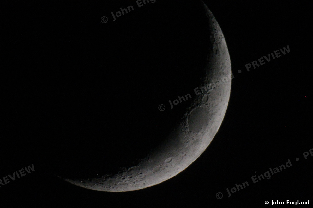 Slender Crescent Moon – Thin crescent moon on black sky.