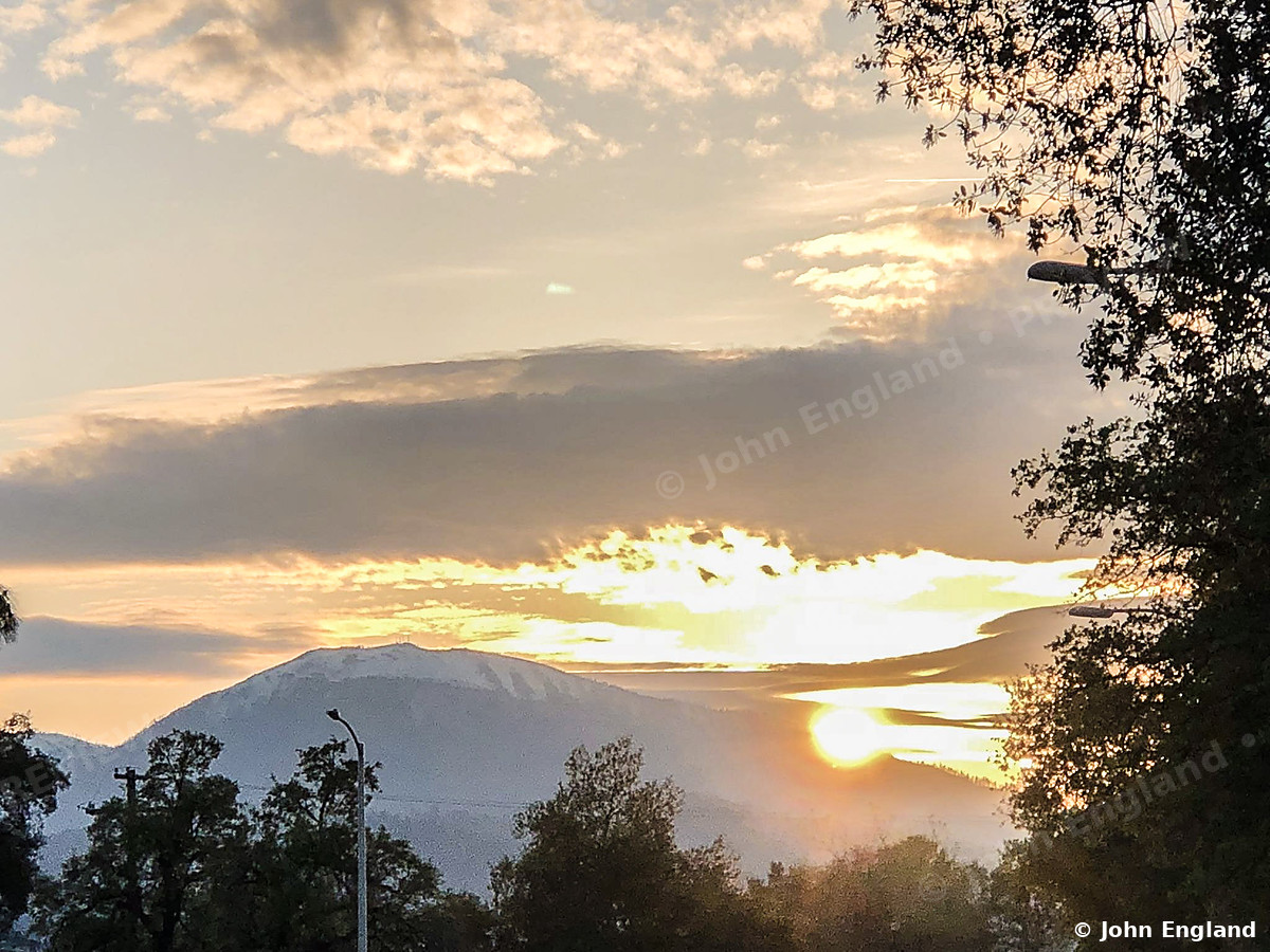 Sunset Behind Snowy Peaks – Sunset behind snow-capped mountains, Redding area, Northern California, Apr 14, 2019.