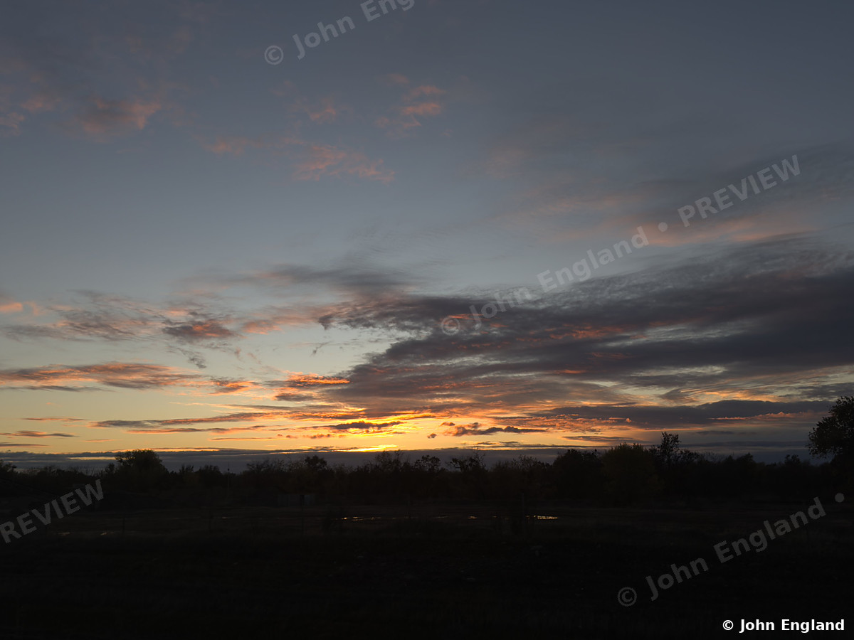 Valley Sunset Clouds – Dramatic sunset clouds over a flat Northern California tree line.