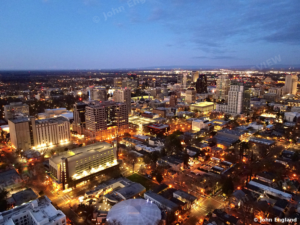 Downtown Sacramento Lights from Above – Aerial view of downtown Sacramento at dusk, city lights coming on, Sacramento, CA. Mar 2022. John England.