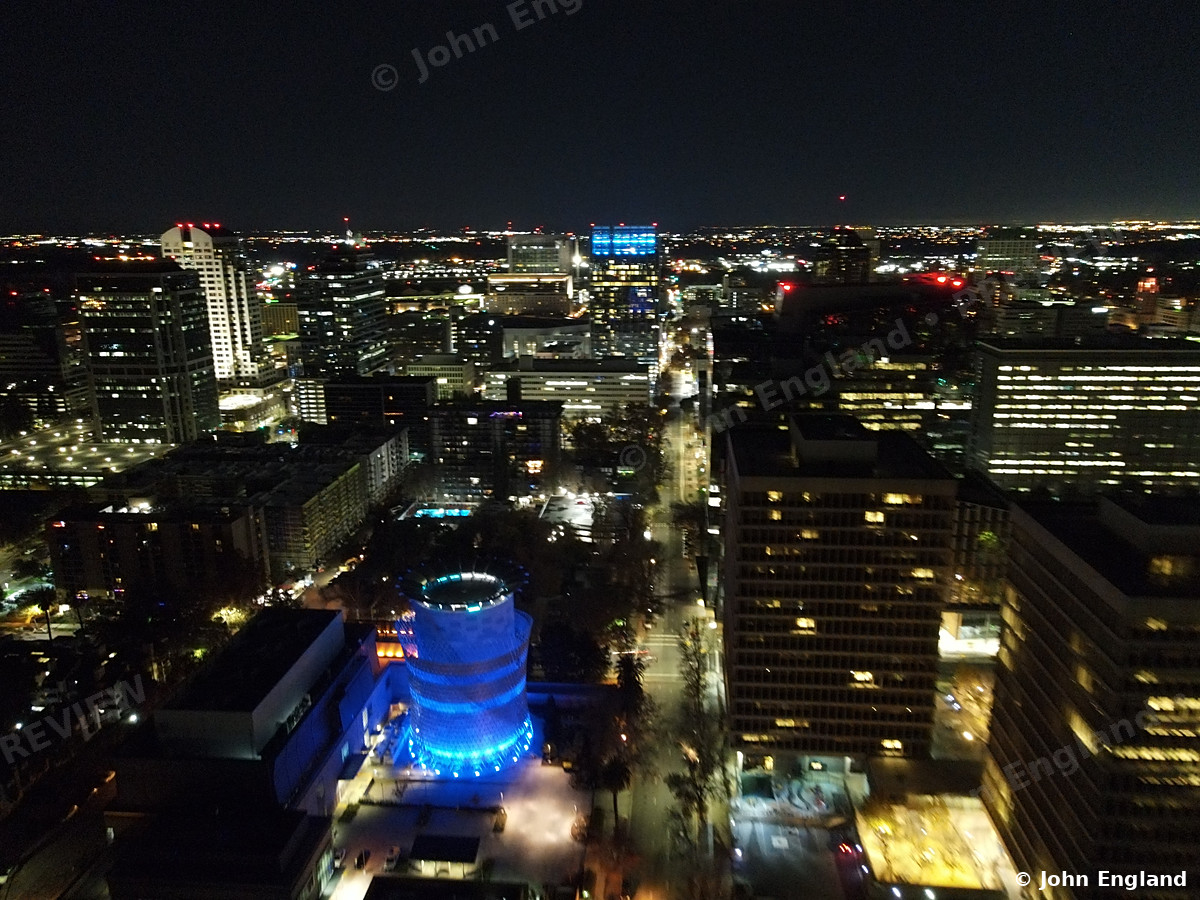 Downtown at Night from Above – Aerial night view over downtown Sacramento lit towers and blue-lit dome building.