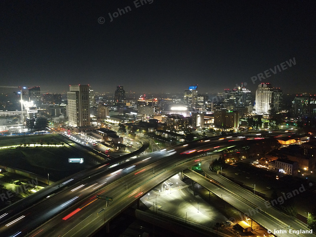 Freeway Light Trails into Downtown – Aerial night shot of freeway interchange light trails leading into the Sacramento skyline.