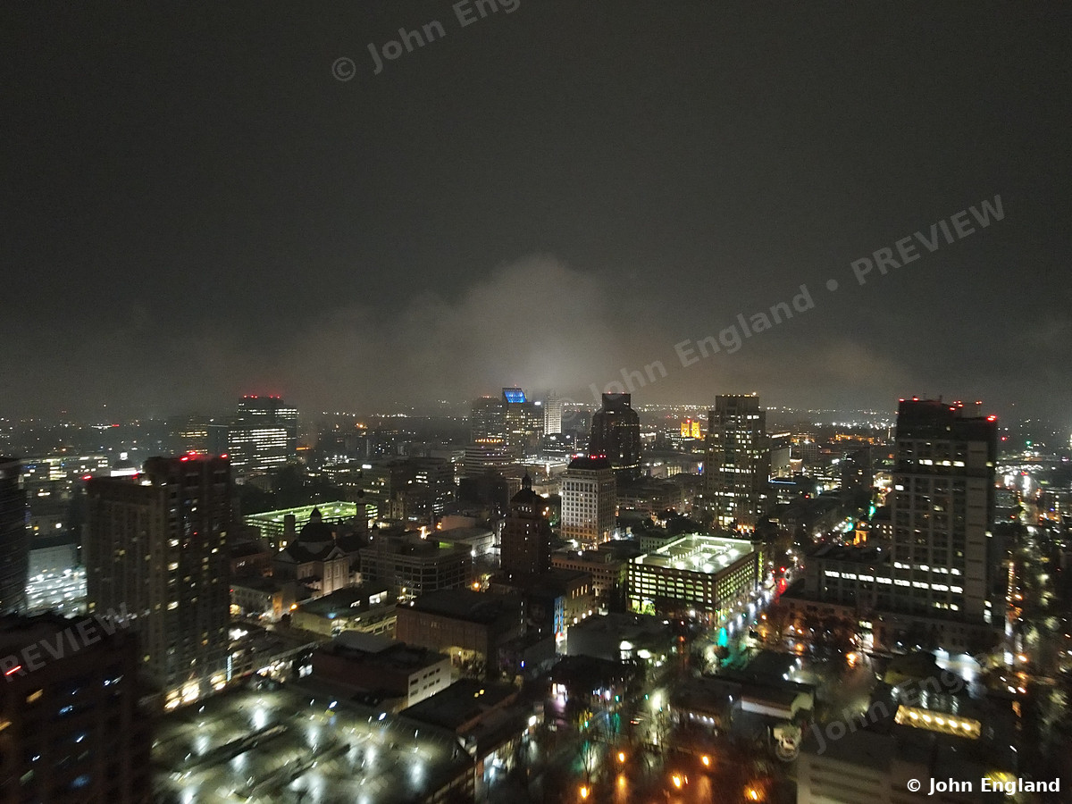 Misty Night Skyline – Aerial night with mist over downtown towers.