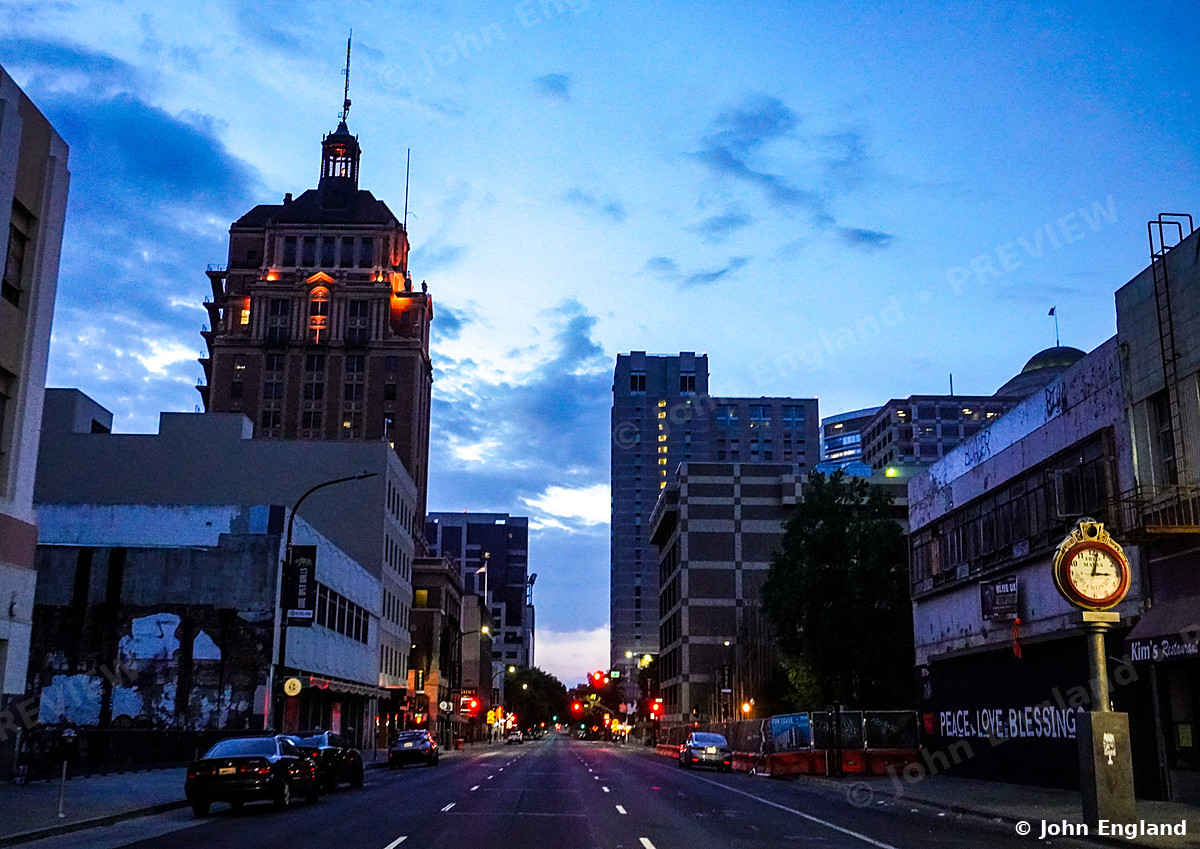 Morning on a Downtown Sacramento Street – Early-morning street view in downtown Sacramento with a historic domed tower and street clock, CA. May 2021. John England.