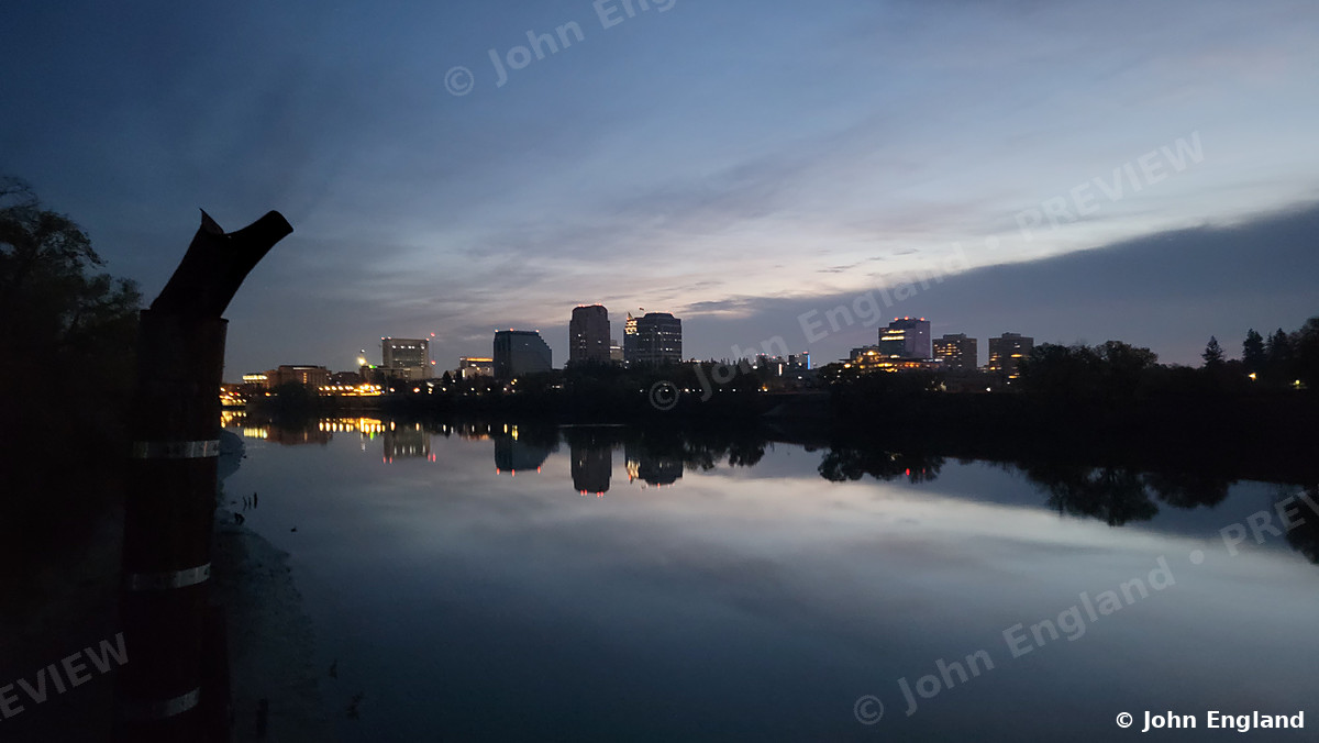 Sacramento Skyline Reflected at Dawn – Sacramento skyline reflected in the river at dawn, Sacramento, CA. Nov 26, 2021. John England.