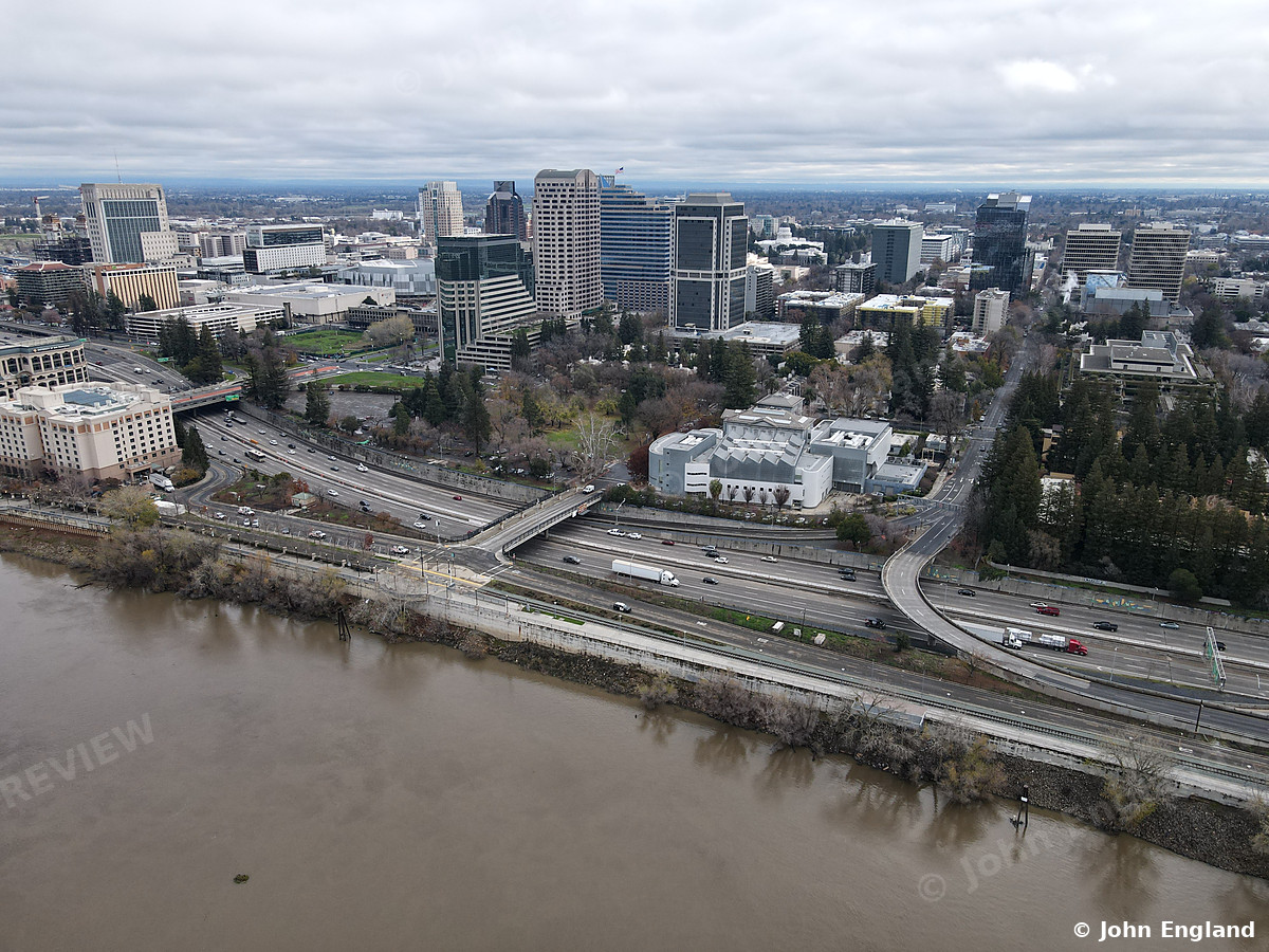 Riverfront Freeway and Skyline – Aerial of river, riverside freeway and downtown towers under overcast sky.