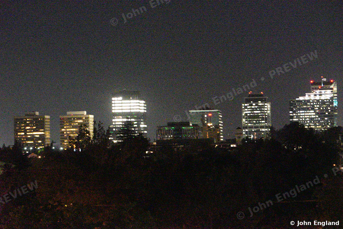Downtown Towers Glowing at Night – Downtown skyline at night across the trees, Aug 11, 2021.