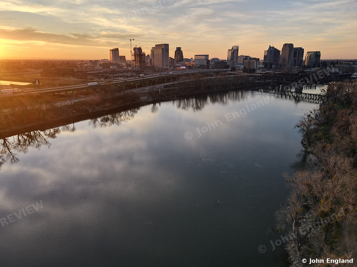 Skyline Mirrored at Sunset – Aerial of the river reflecting the downtown skyline at sunset.