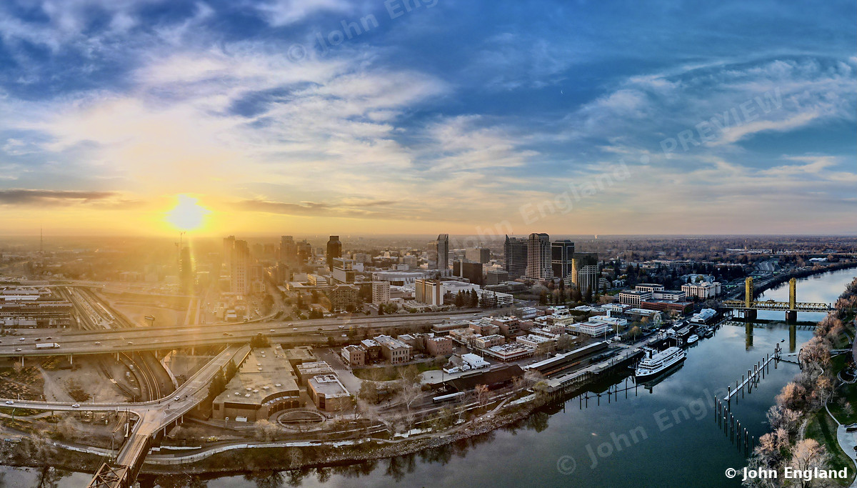 Sunrise over the Sacramento River and Downtown – Aerial sunrise over the Sacramento River and downtown Sacramento, CA. Feb 2022. John England.