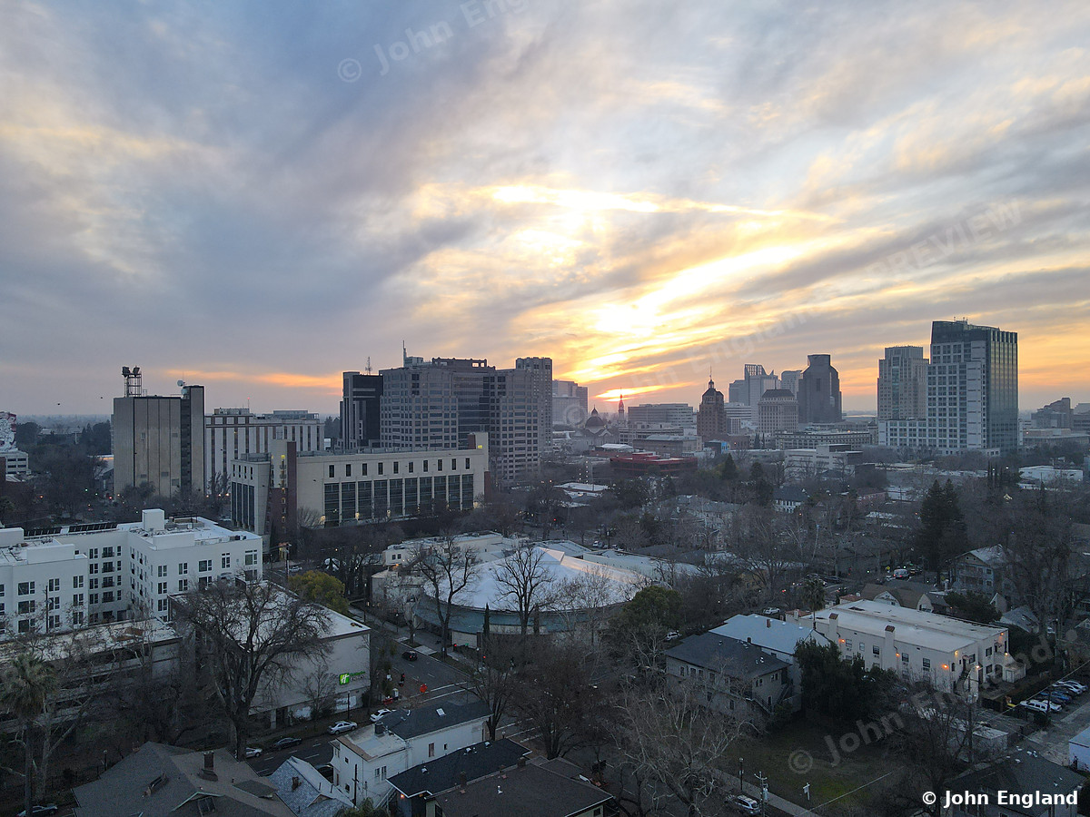 Sunset Sky over Midtown – Aerial of streaked sunset clouds above midtown and downtown towers.