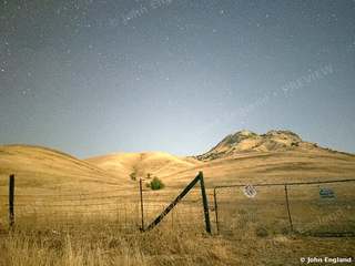 Stars over the Fence Line – Stars over golden foothills behind a fence line, Northern California.