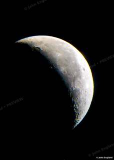 Crescent Detail – Crescent moon with crisp terminator craters on black.
