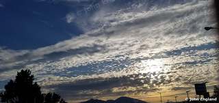 Redding Sunset Under Dappled Clouds – Sunset under dappled clouds over distant mountains, Redding area, CA. July 2019. John England.