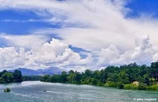 Summer River Cumulus – Sacramento River under towering summer cumulus with distant mountains.