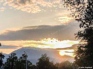 Sunset Behind Snowy Peaks – Sunset behind snow-capped mountains, Redding area, Northern California, Apr 14, 2019.