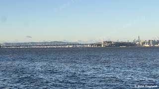 Bay Bridge Morning, San Francisco – San Francisco skyline and Bay Bridge across the Bay from the Berkeley shore at sunrise.