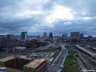 Cloudy Skyline over Rail Yard – Aerial of downtown with clouds and rail corridor.