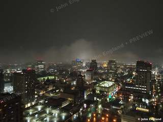 Misty Night Skyline – Aerial night with mist over downtown towers.
