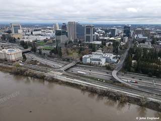Riverfront Freeway and Skyline – Aerial of river, riverside freeway and downtown towers under overcast sky.