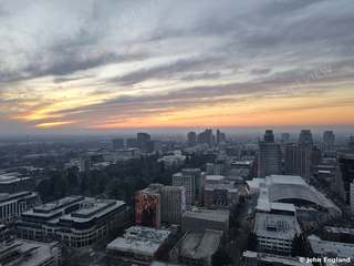 Wide Dusk Cityscape – Aerial of downtown skyline at dusk under streaked clouds.