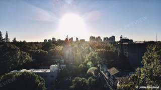 Sun Over the Sacramento Skyline – Drone view of the sun setting over tree-lined Midtown toward the downtown Sacramento skyline. Aug 9, 2022. John England.