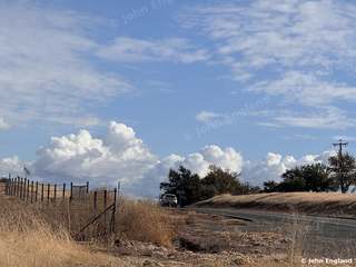 Summer Clouds Over the Foothills – Towering cumulus clouds over dry foothills and a country road. Oct 28, 2024. John England.